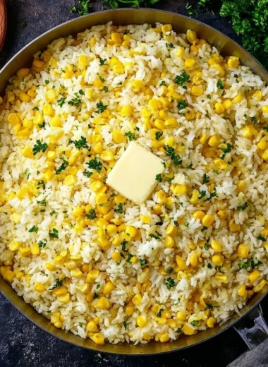 A bowl of buttered corn rice with herbs and spices, garnished for a tasty meal.
