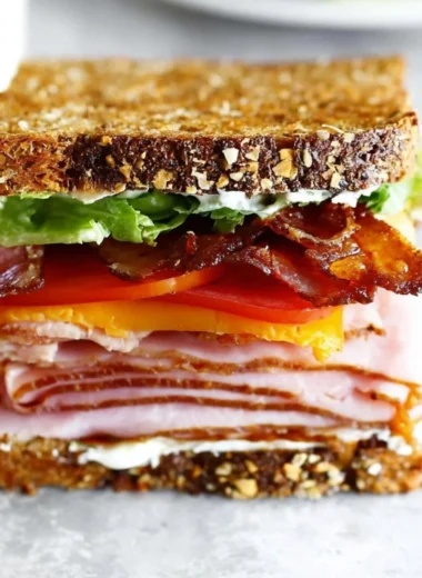 Delectable club sandwich with turkey, ham, and bacon layers stacked high