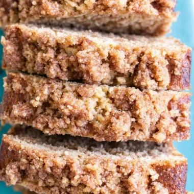 Slice of coffee cake banana bread on a plate with a coffee cup