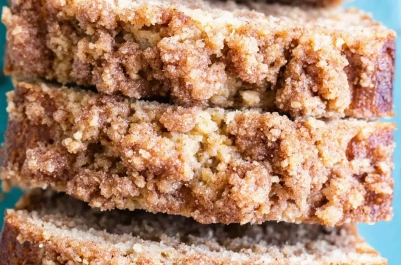 Slice of coffee cake banana bread on a plate with a coffee cup
