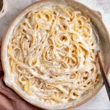 Bowl of Cottage Cheese Alfredo pasta with fresh herbs and a creamy sauce