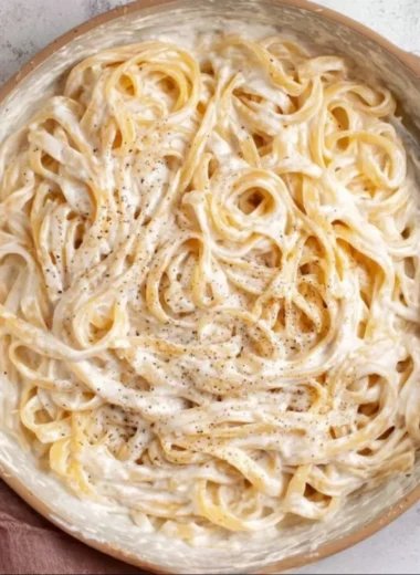 Bowl of Cottage Cheese Alfredo pasta with fresh herbs and a creamy sauce