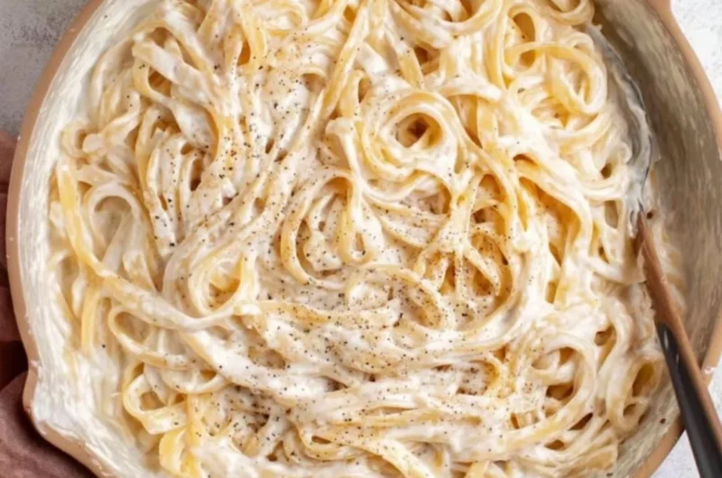 Bowl of Cottage Cheese Alfredo pasta with fresh herbs and a creamy sauce