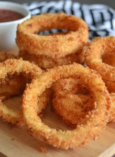 A plate of crispy onion rings with a golden-brown coating