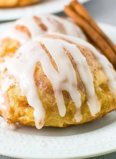 Fresh peach fritters served on a plate, golden and fluffy.
