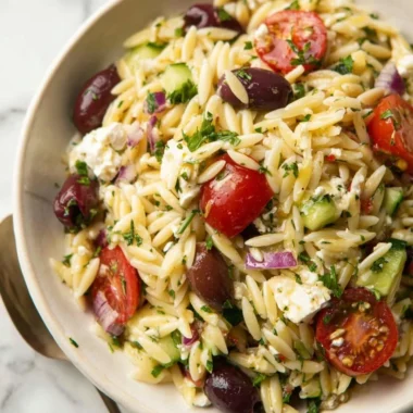Colorful Greek Orzo Pasta Salad with vegetables and feta cheese