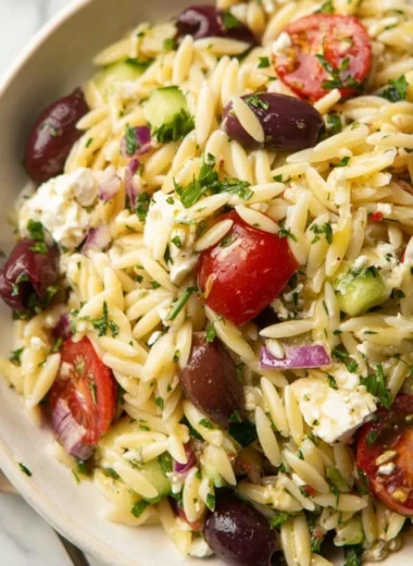 Colorful Greek Orzo Pasta Salad with vegetables and feta cheese