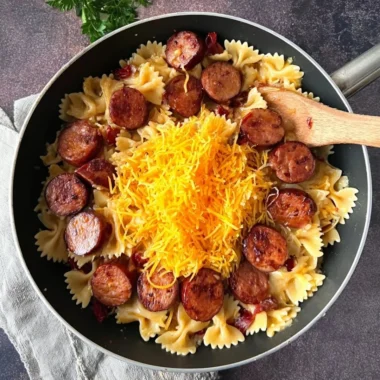 One pot creamy Cajun sausage pasta served in a bowl with fresh herbs