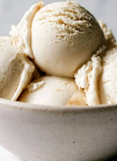 Delicious bowl of homemade coconut ice cream topped with coconut flakes