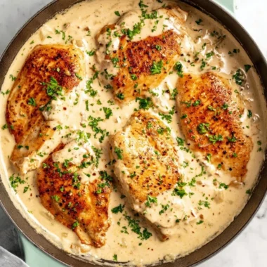 Delicious easy cream cheese chicken served on a plate with herbs.