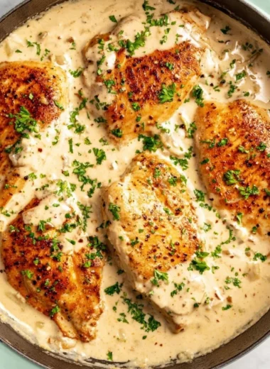 Delicious easy cream cheese chicken served on a plate with herbs.