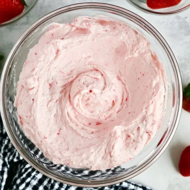 Delicious fresh strawberry buttercream topped on a cupcake