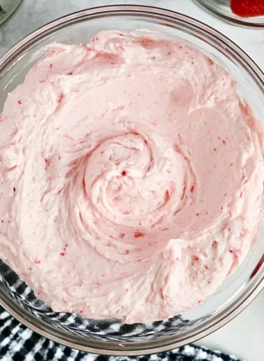 Delicious fresh strawberry buttercream topped on a cupcake