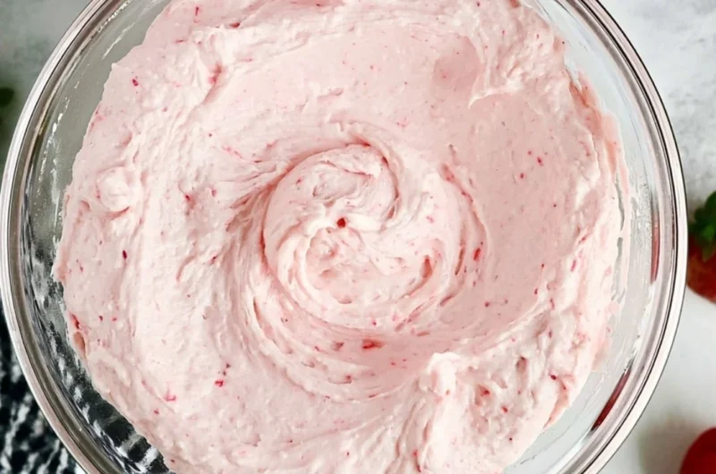 Delicious fresh strawberry buttercream topped on a cupcake