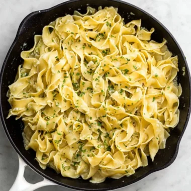 Delicious hot buttered egg noodles served in a bowl with herbs
