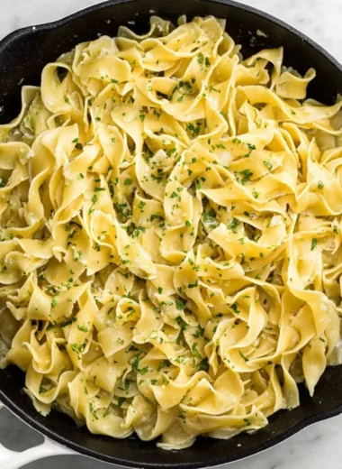 Delicious hot buttered egg noodles served in a bowl with herbs