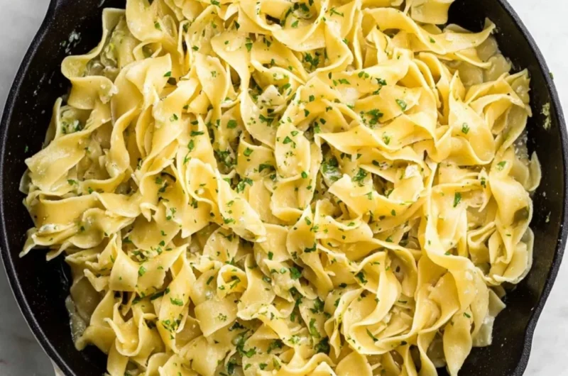 Delicious hot buttered egg noodles served in a bowl with herbs