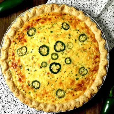 Delicious jalapeno popper quiche topped with cheese and jalapenos