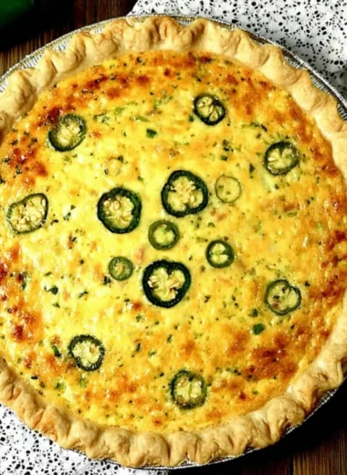 Delicious jalapeno popper quiche topped with cheese and jalapenos