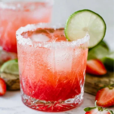 Strawberry Lime Mocktail Margarita served in a glass with fresh strawberries and lime slices.