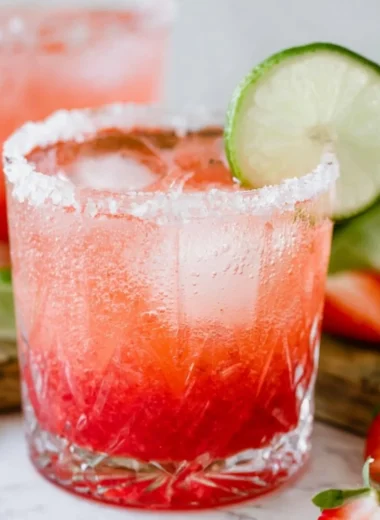 Strawberry Lime Mocktail Margarita served in a glass with fresh strawberries and lime slices.