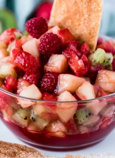 Sweet fruit salad served with cinnamon sugar tortilla chips in a colorful bowl.
