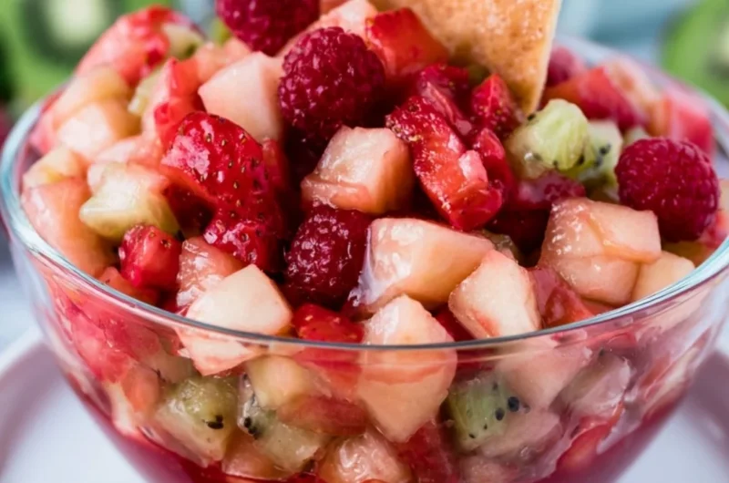 Sweet fruit salad served with cinnamon sugar tortilla chips in a colorful bowl.