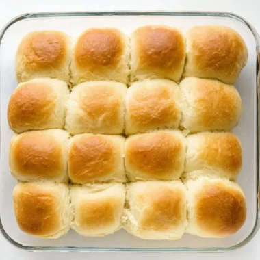 Freshly baked Texas Roadhouse Rolls with honey butter spread on top.