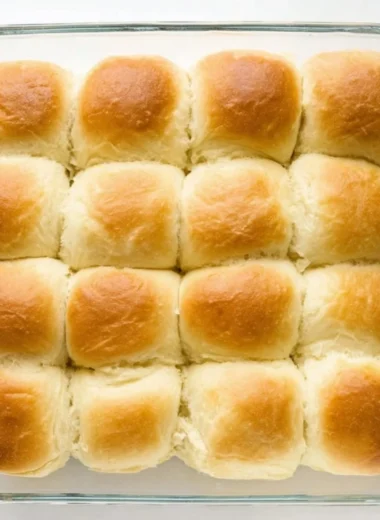 Freshly baked Texas Roadhouse Rolls with honey butter spread on top.