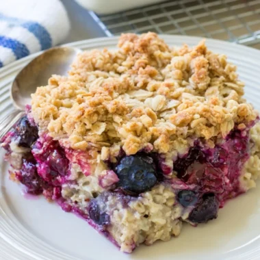 Bowl of blueberry baked oatmeal topped with fresh blueberries and almonds