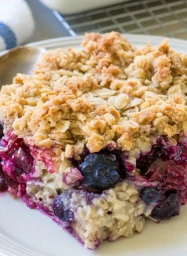 Bowl of blueberry baked oatmeal topped with fresh blueberries and almonds