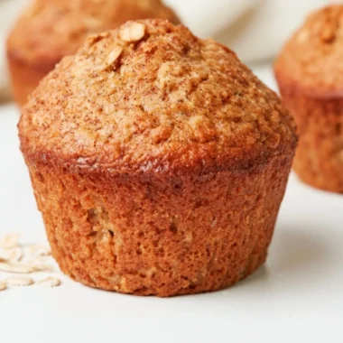 Baked healthy banana oatmeal muffins topped with oats and bananas.