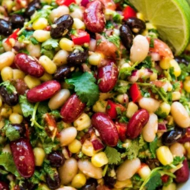 A colorful bowl of healthy Mexican Bean Salad with beans, vegetables, and dressing