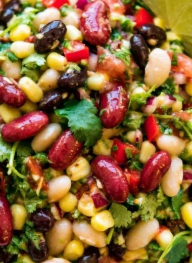 A colorful bowl of healthy Mexican Bean Salad with beans, vegetables, and dressing