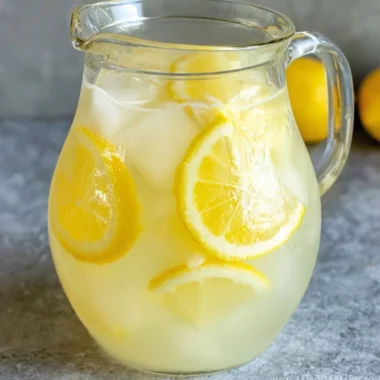 Glass of homemade lemonade with lemon slices and mint leaves