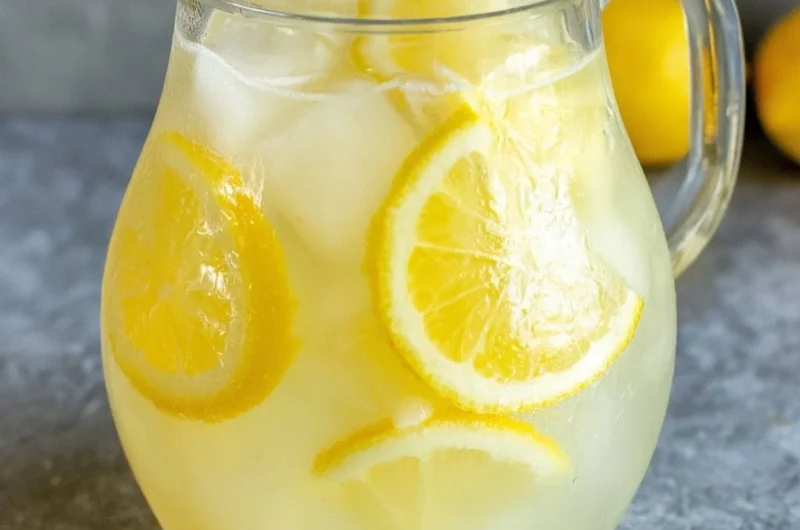 Glass of homemade lemonade with lemon slices and mint leaves