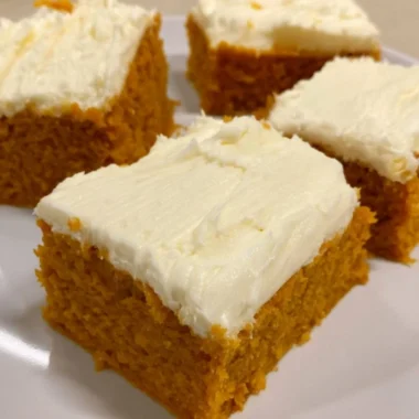 Delicious homemade pumpkin cream cheese bars on a plate with autumn decorations