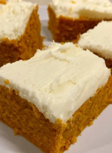 Delicious homemade pumpkin cream cheese bars on a plate with autumn decorations