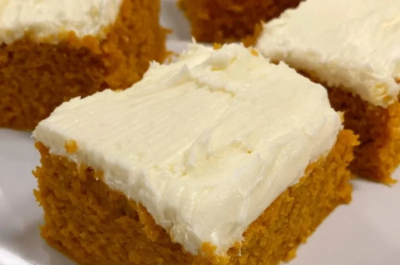 Delicious homemade pumpkin cream cheese bars on a plate with autumn decorations