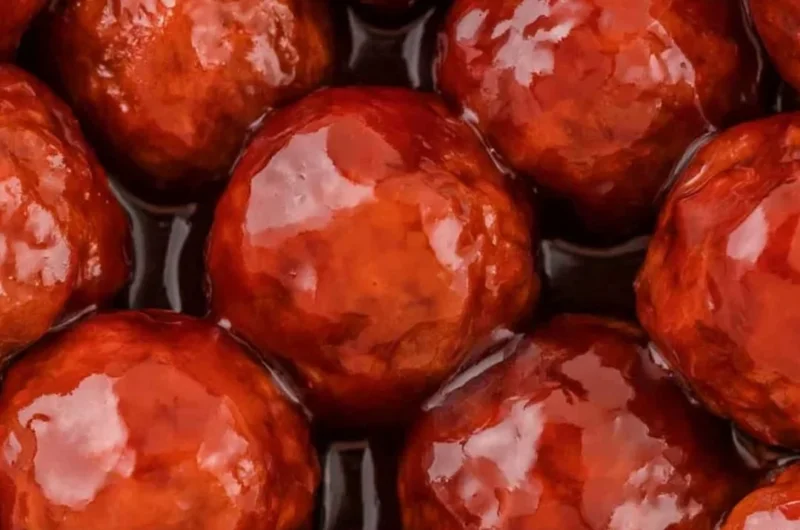 Crockpot meatballs in grape jelly and BBQ sauce served on a platter.