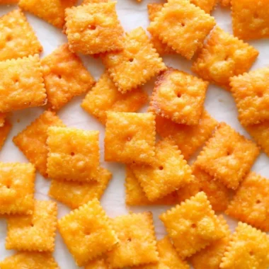 Bowl of crunchy homemade cheese crackers on a rustic wooden table