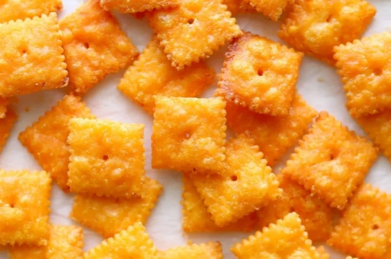 Bowl of crunchy homemade cheese crackers on a rustic wooden table
